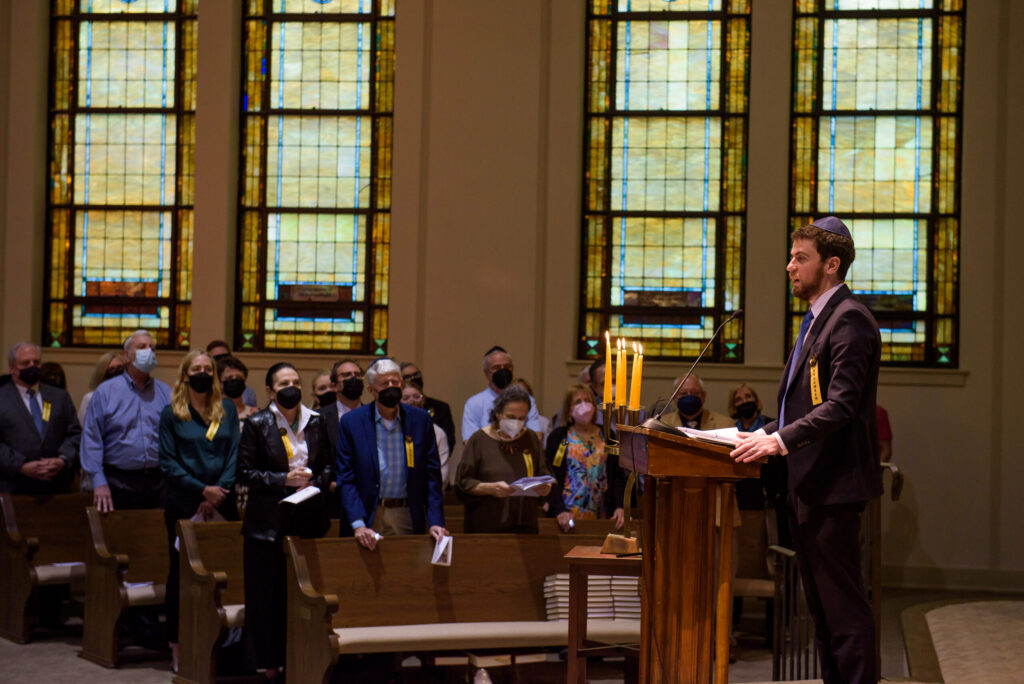 Man wearing Yamaka standing at podium at Synagogue