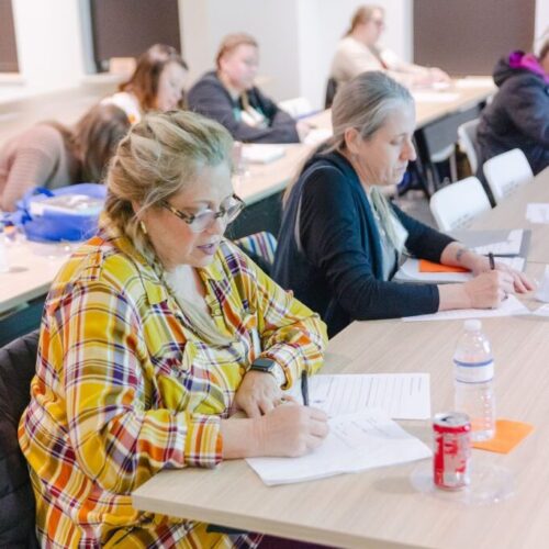 ladies writing down on paper in class