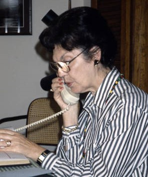 Edith Sanders talking on the phoen wearing stipped shirt